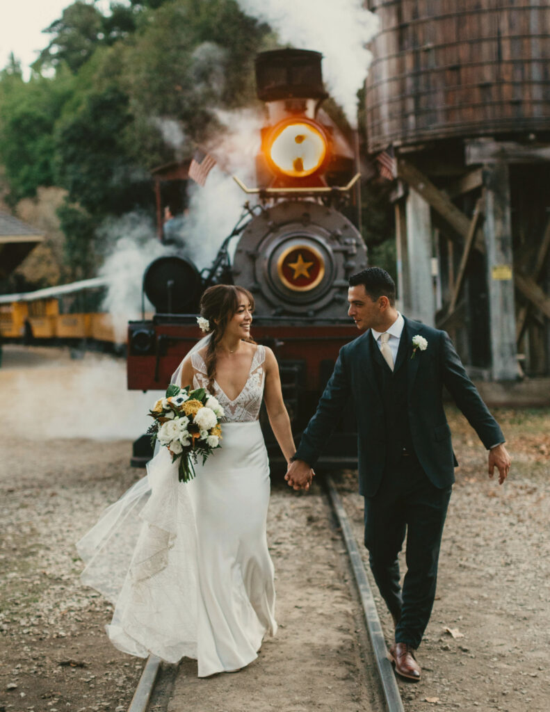 wedding couple walking in front of steam train